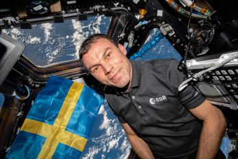 Marcus Wandt med svensk flagga i Cupolan på den internationella rymdstationen